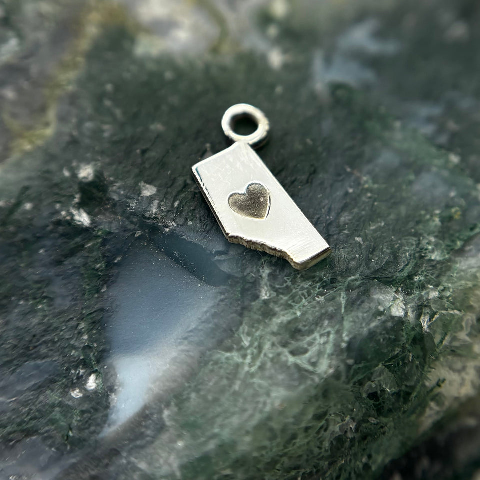 Silver Alberta-shaped charm with a heart cutout
