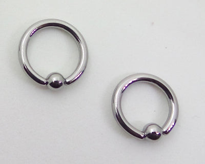 Two polished captive bead rings on a pale background