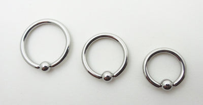 Three polished titanium captive bead rings