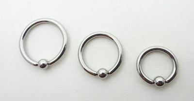 Three polished titanium captive bead rings