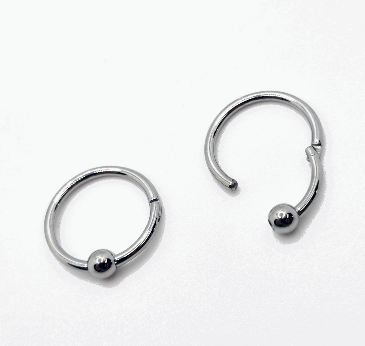 Polished titanium captive bead rings shown open and closed