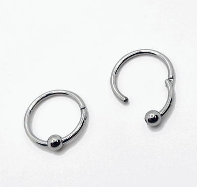 Polished titanium captive bead rings shown open and closed