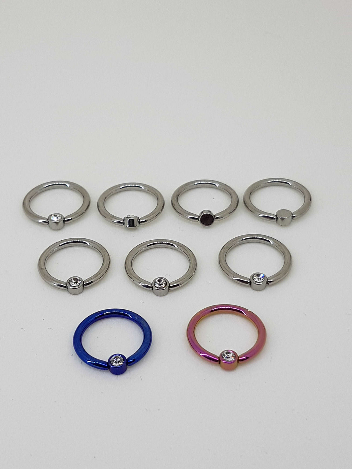 Polished, blue and pink captive bead rings