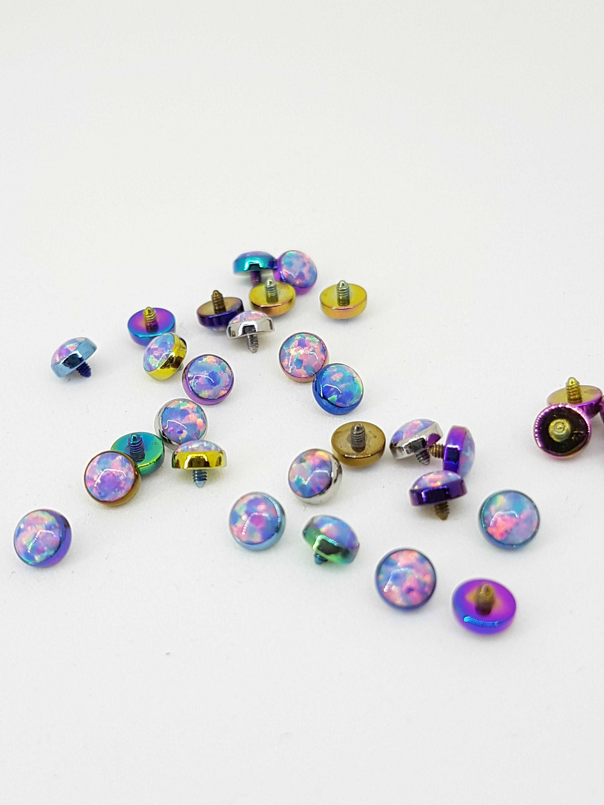 Pastel opal-look jewelry ends in multicoloured titanium settings