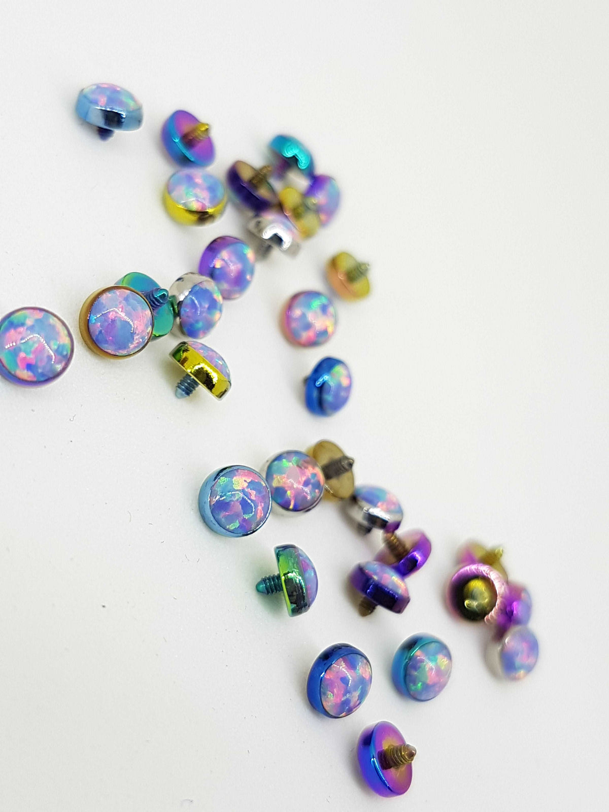 Pastel opal-look jewelry ends in multicoloured titanium settings