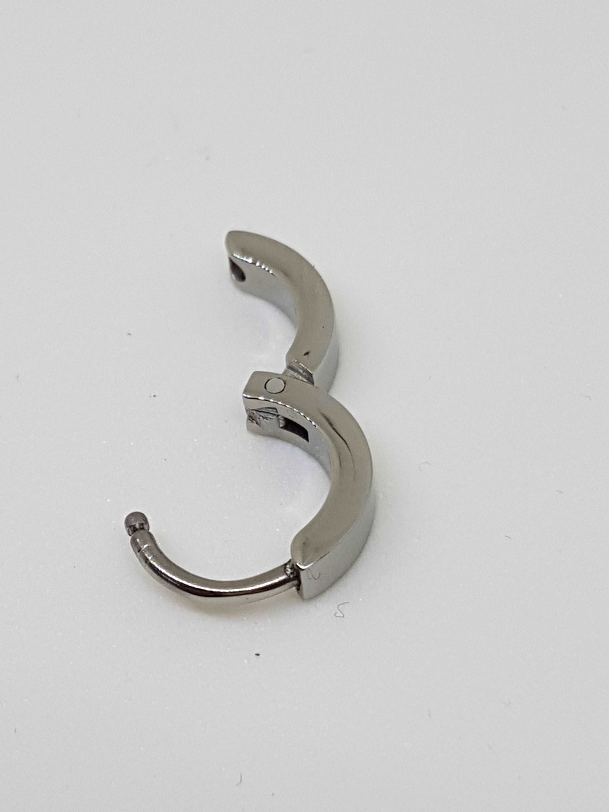 Polished titanium clicker with its hinged section open