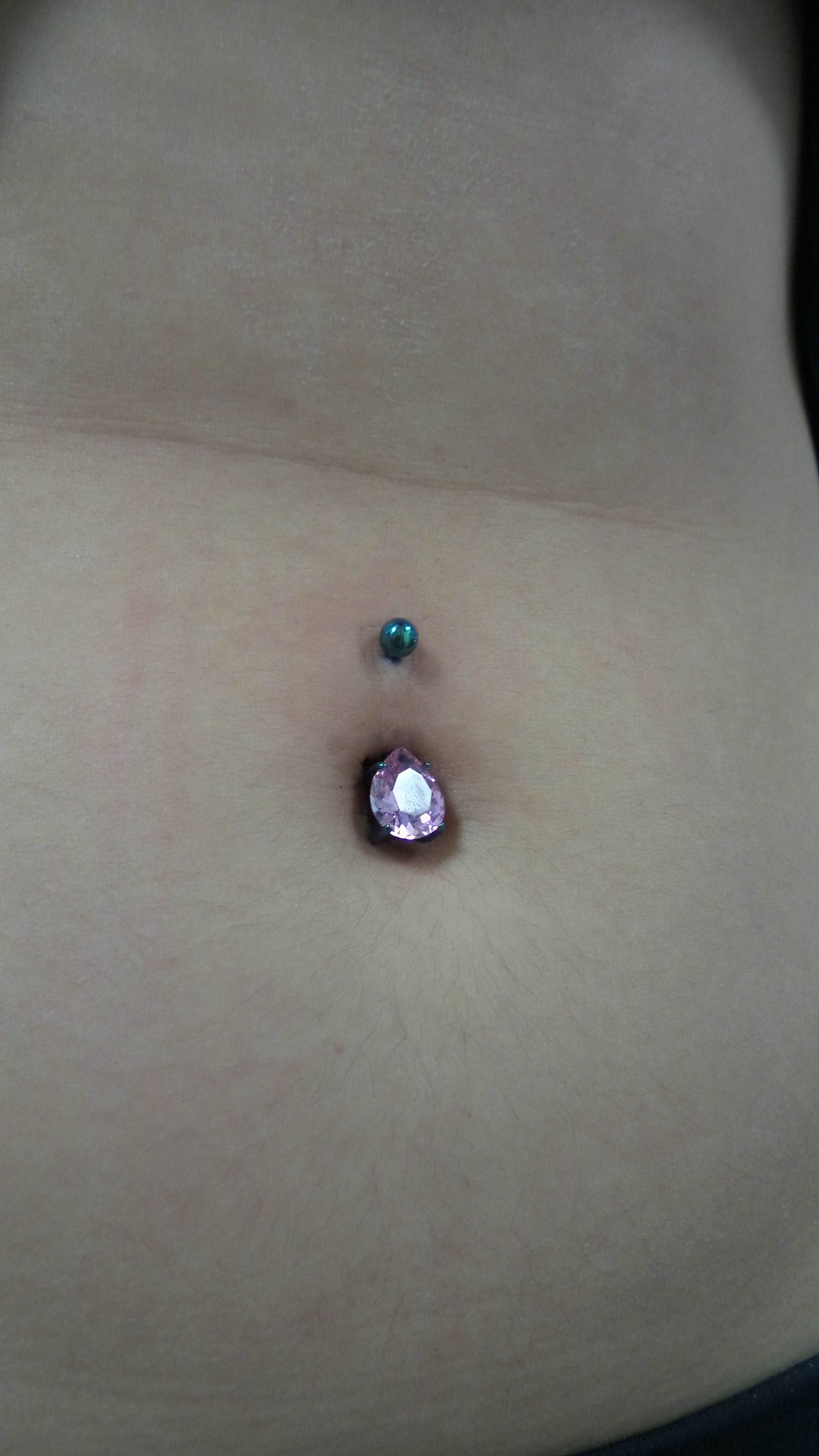 Purple gemstone jewelry worn in a navel piercing