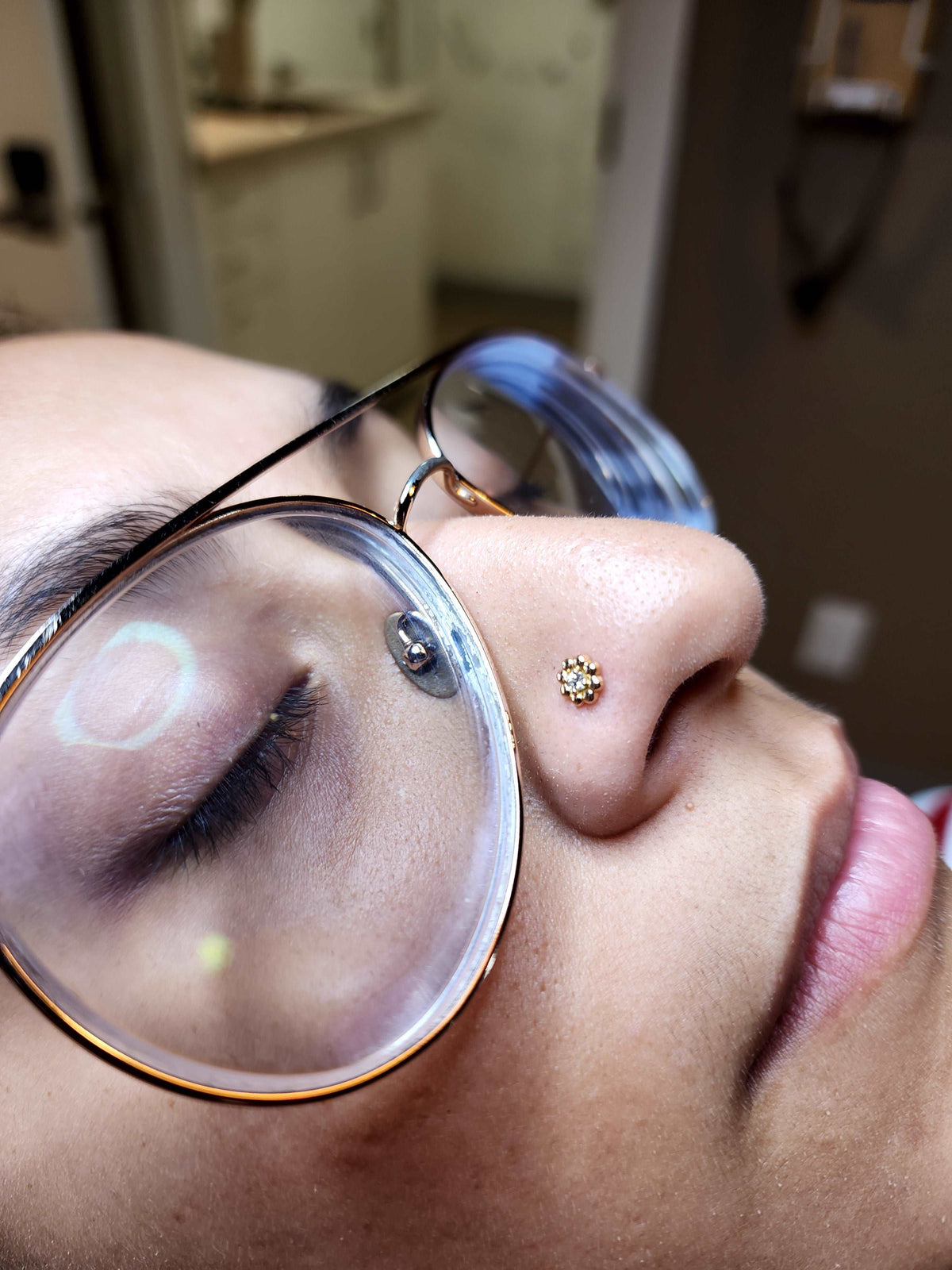 Gold diamond jewelry worn in a nostril piercing