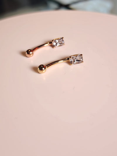 Yellow and rose gold curved navel barbells with white sapphire ends