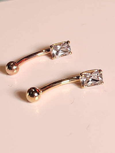 Yellow and rose gold curved navel barbells with white sapphire ends