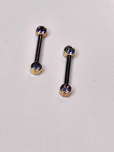 Front-facing barbells with iolite gemstones in gold bezel settings