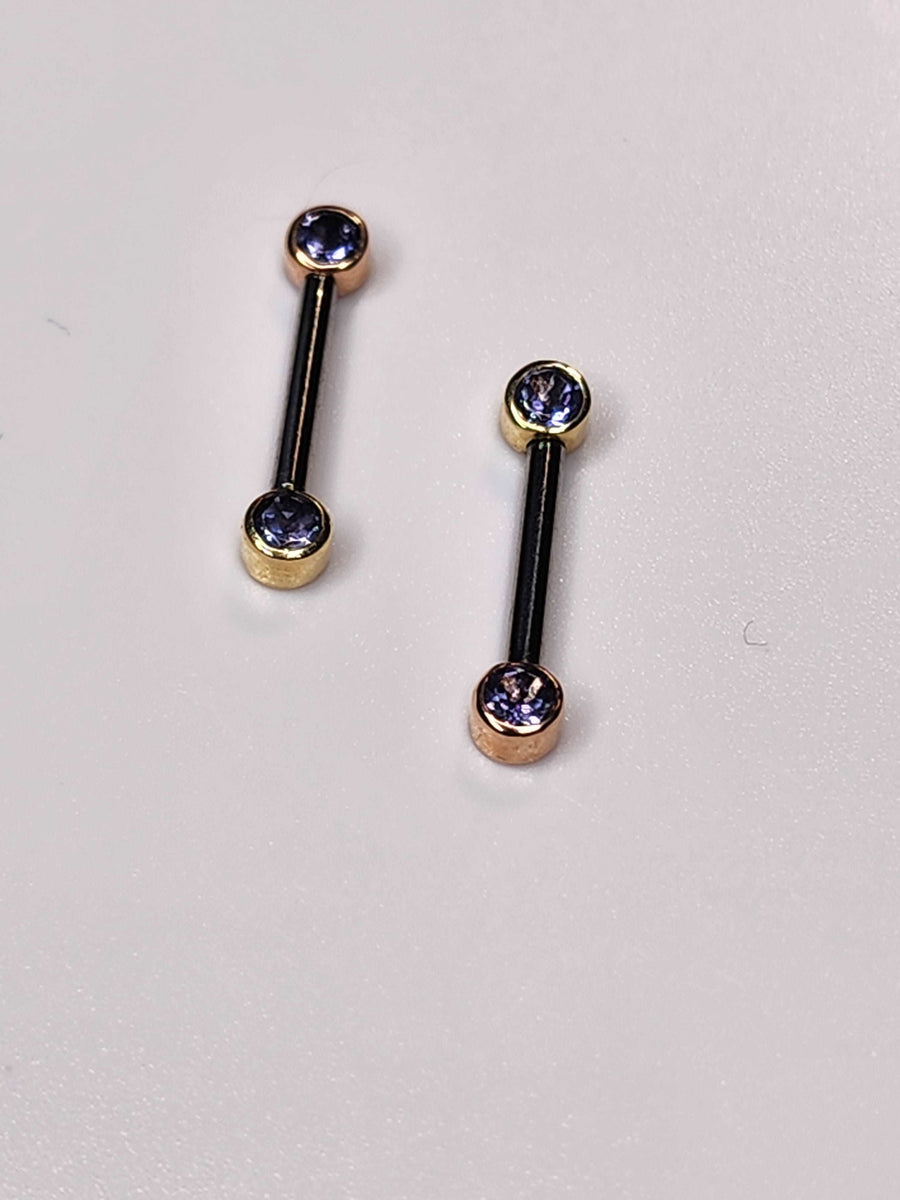 Front-facing barbells with iolite gemstones in gold bezel settings