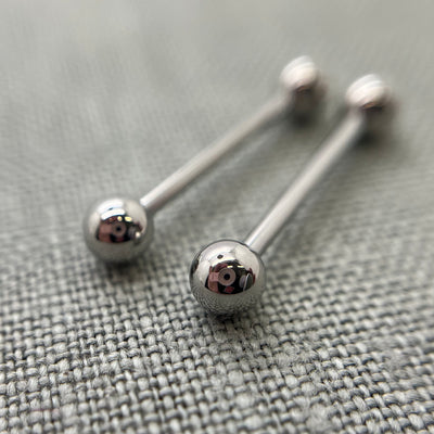 Two polished stainless steel straight barbells on grey fabric