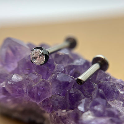 Clear cubic zirconia in a black niobium setting on purple crystal