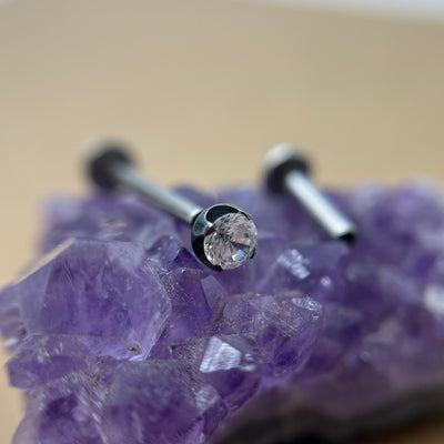 Clear cubic zirconia in a black niobium setting on purple crystal