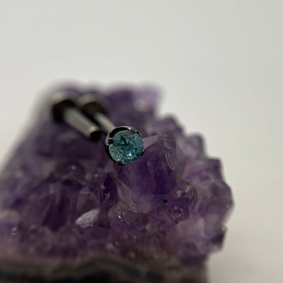 Aqua gemstone jewelry in a black niobium setting on purple crystal