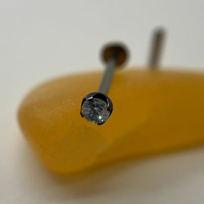 Blue gemstone jewelry in a black niobium setting on a yellow display