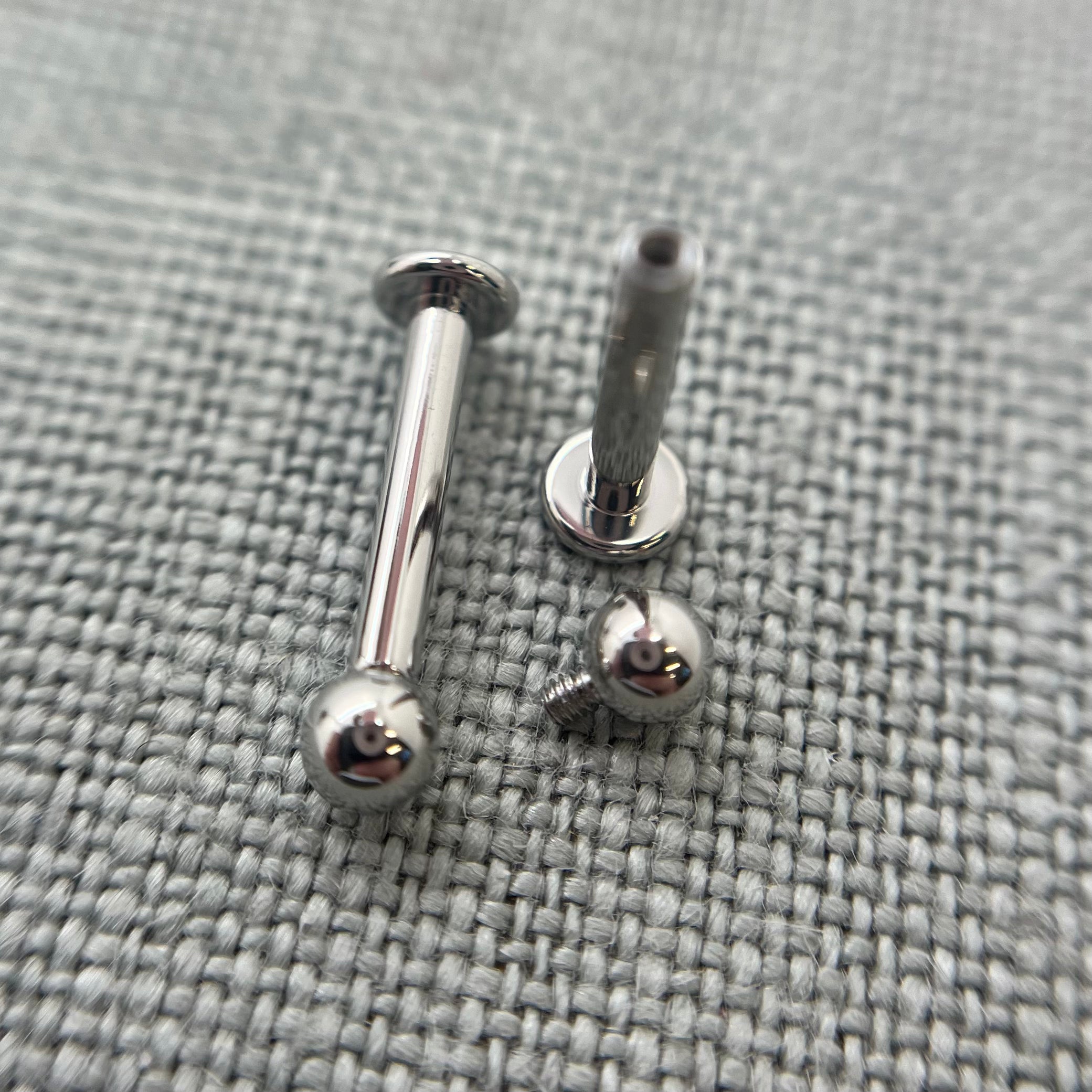 Stainless steel flat-back labrets with a threaded bead removed