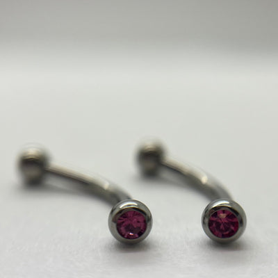 Stainless steel curved barbells with pink cubic zirconia ends