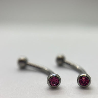 Stainless steel curved barbells with pink cubic zirconia ends