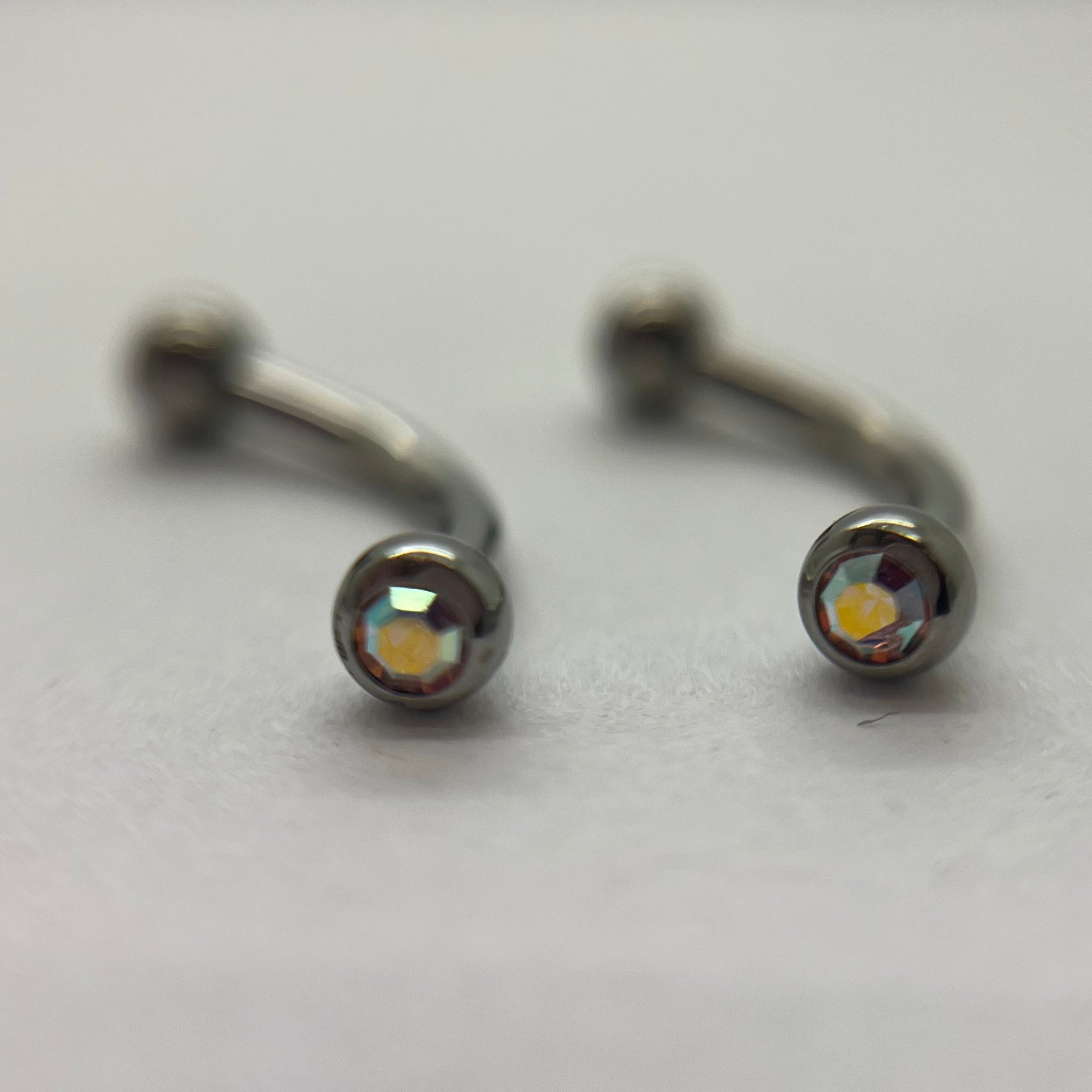 Stainless steel curved barbells with iridescent cubic zirconia ends