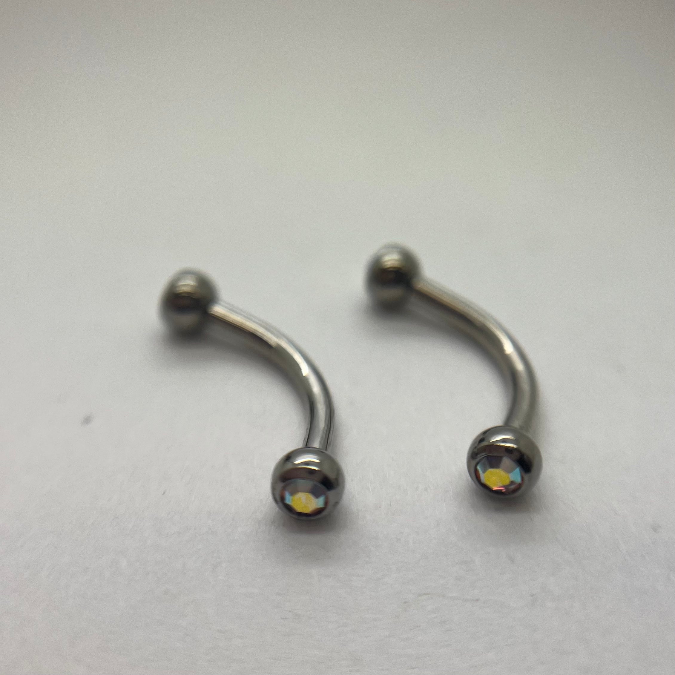 Stainless steel curved barbells with iridescent cubic zirconia ends