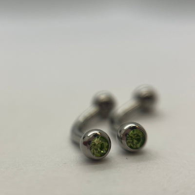 Stainless steel curved barbells with green cubic zirconia ends