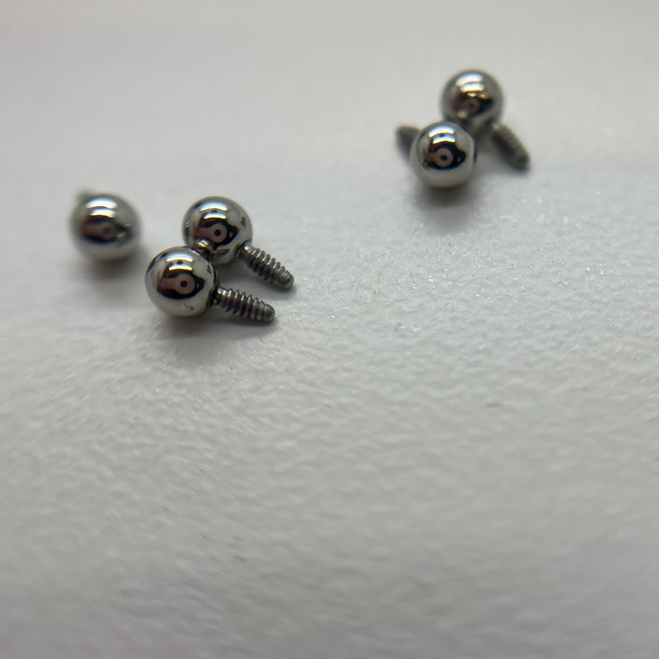 Stainless steel threaded jewelry beads with screw threads visible