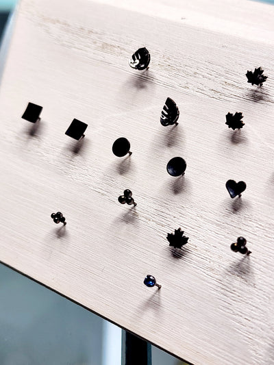 Black rhodium-plated gold jewelry ends in leaf, heart and geometric shapes