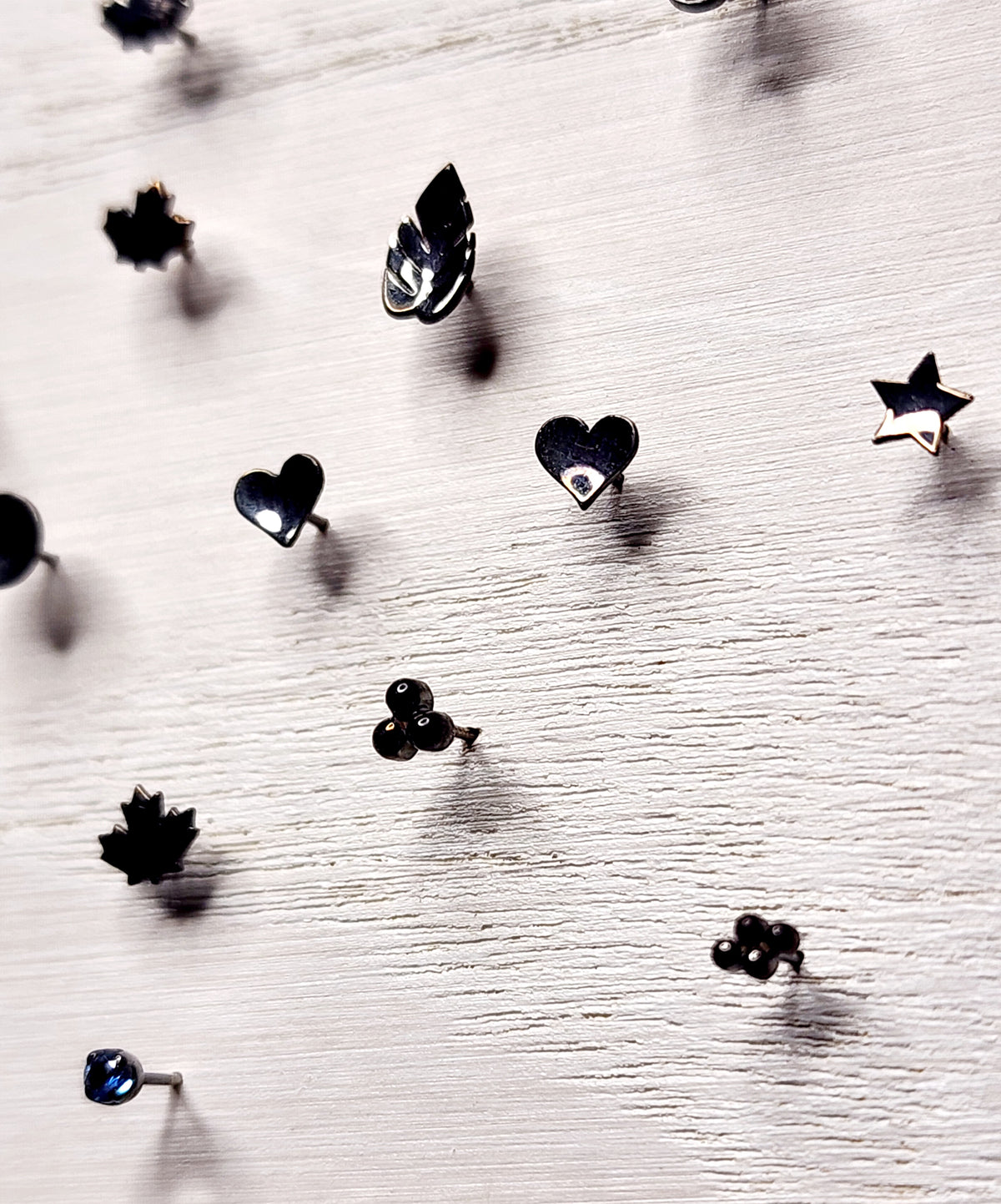 Black rhodium-plated gold jewelry ends in leaf, heart and geometric shapes