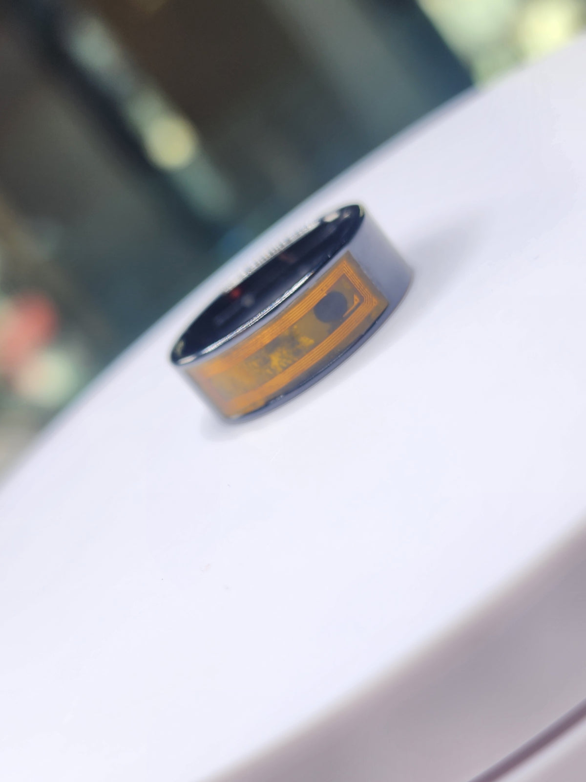 Dark ceramic NFC finger ring with its internal circuit visible