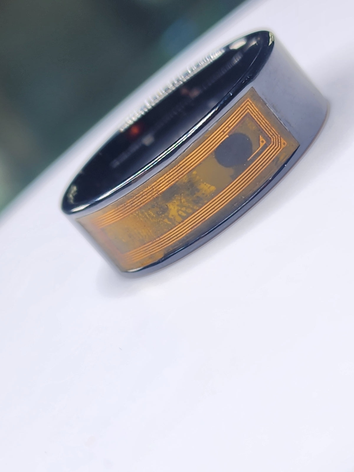 Dark ceramic NFC finger ring with its internal circuit visible