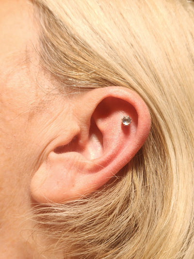 Gemstone stud worn in an upper-ear piercing