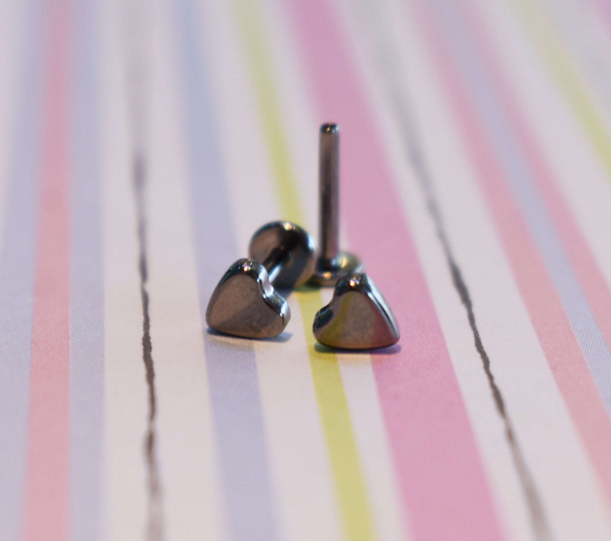 Heart-shaped jewelry ends beside a flat-back post
