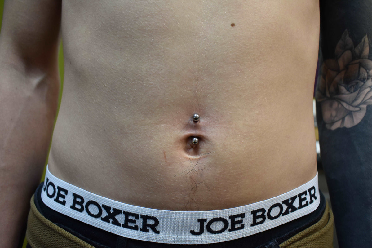 Small curved barbell worn in a navel piercing