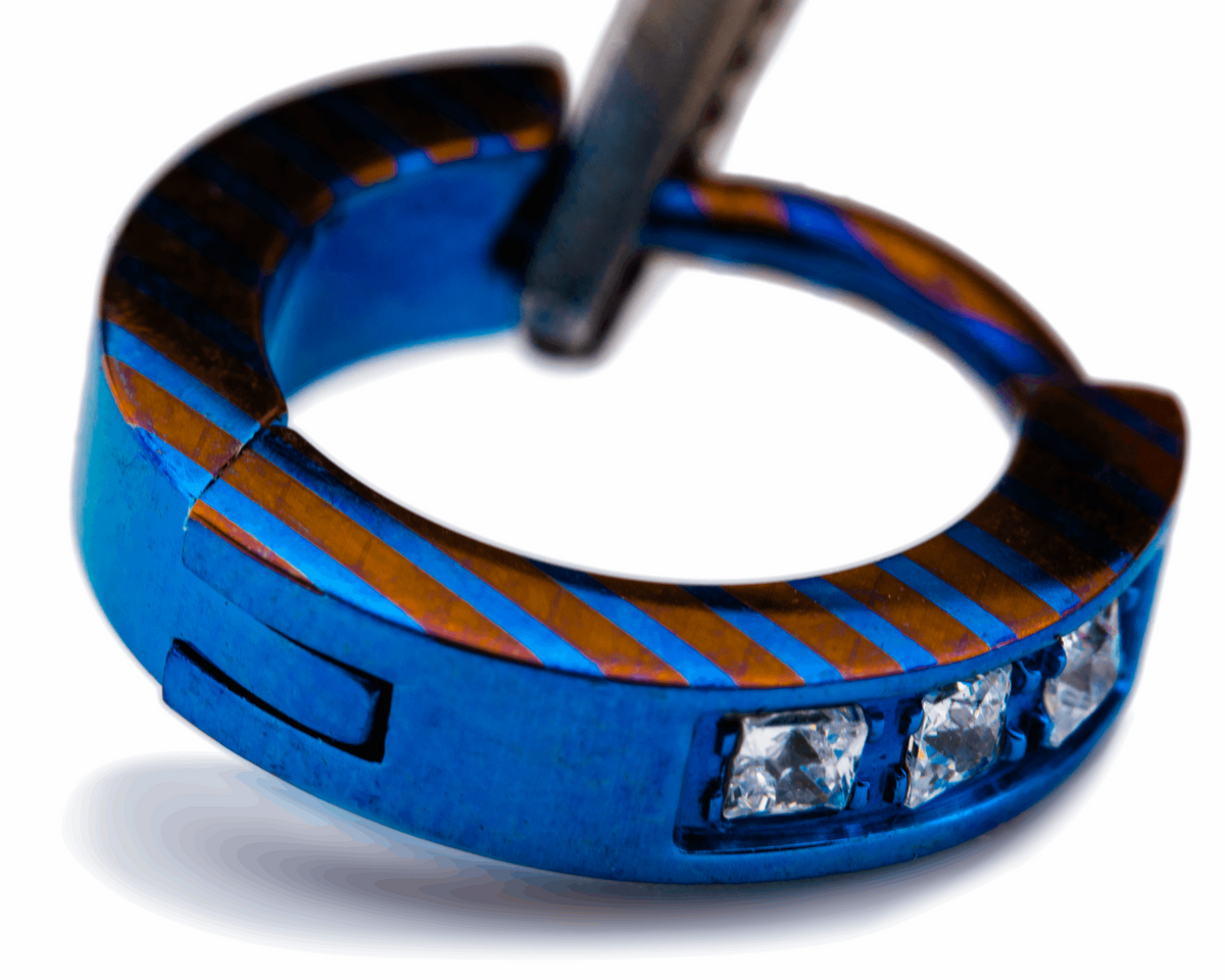 Blue titanium clicker with orange lines and square clear gemstones