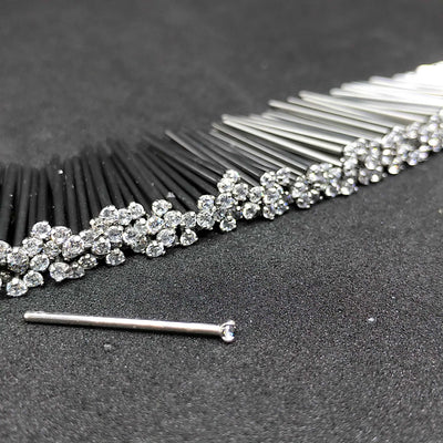 Close-up of clear prong-set titanium nostril studs