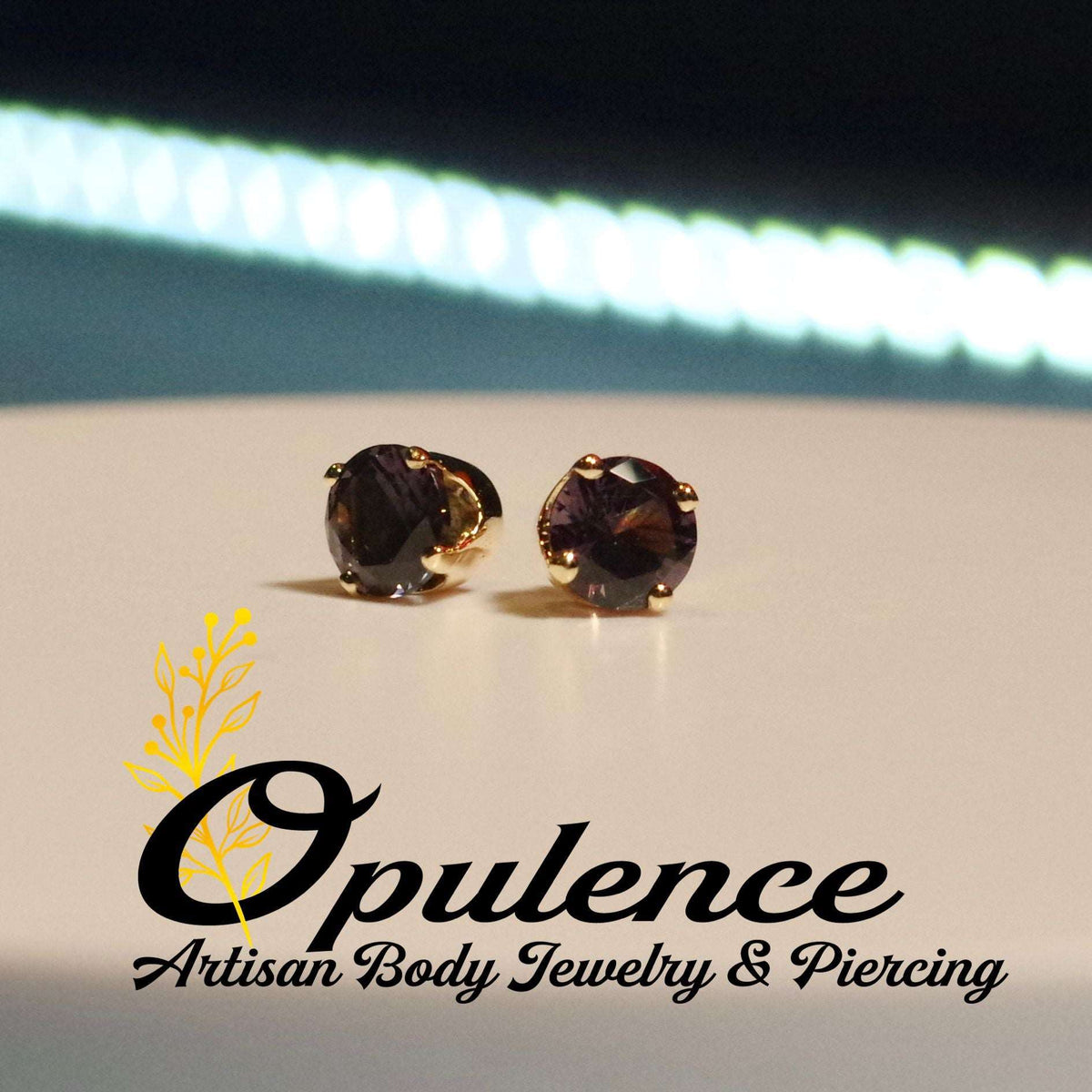 Pair of dark round gemstone jewelry ends in gold settings