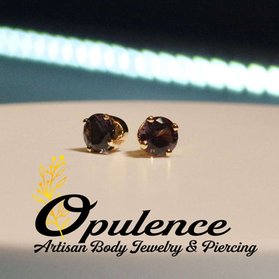 Pair of dark round gemstone jewelry ends in gold settings