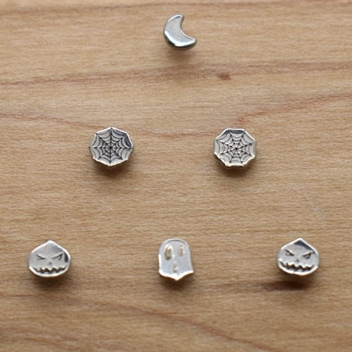 Crescent moon and geometric jewelry ends on a wood display