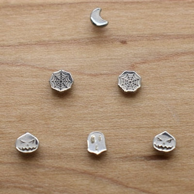Crescent moon and geometric jewelry ends on a wood display