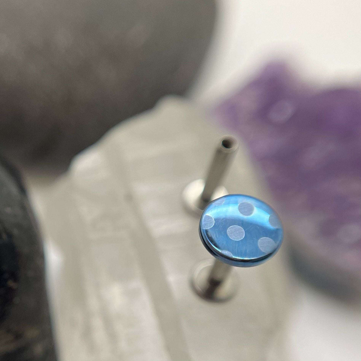 Blue titanium disc with pale blue polka dots on a flat-back post