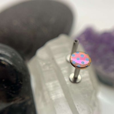 Pink titanium disc with blue polka dots on a flat-back post