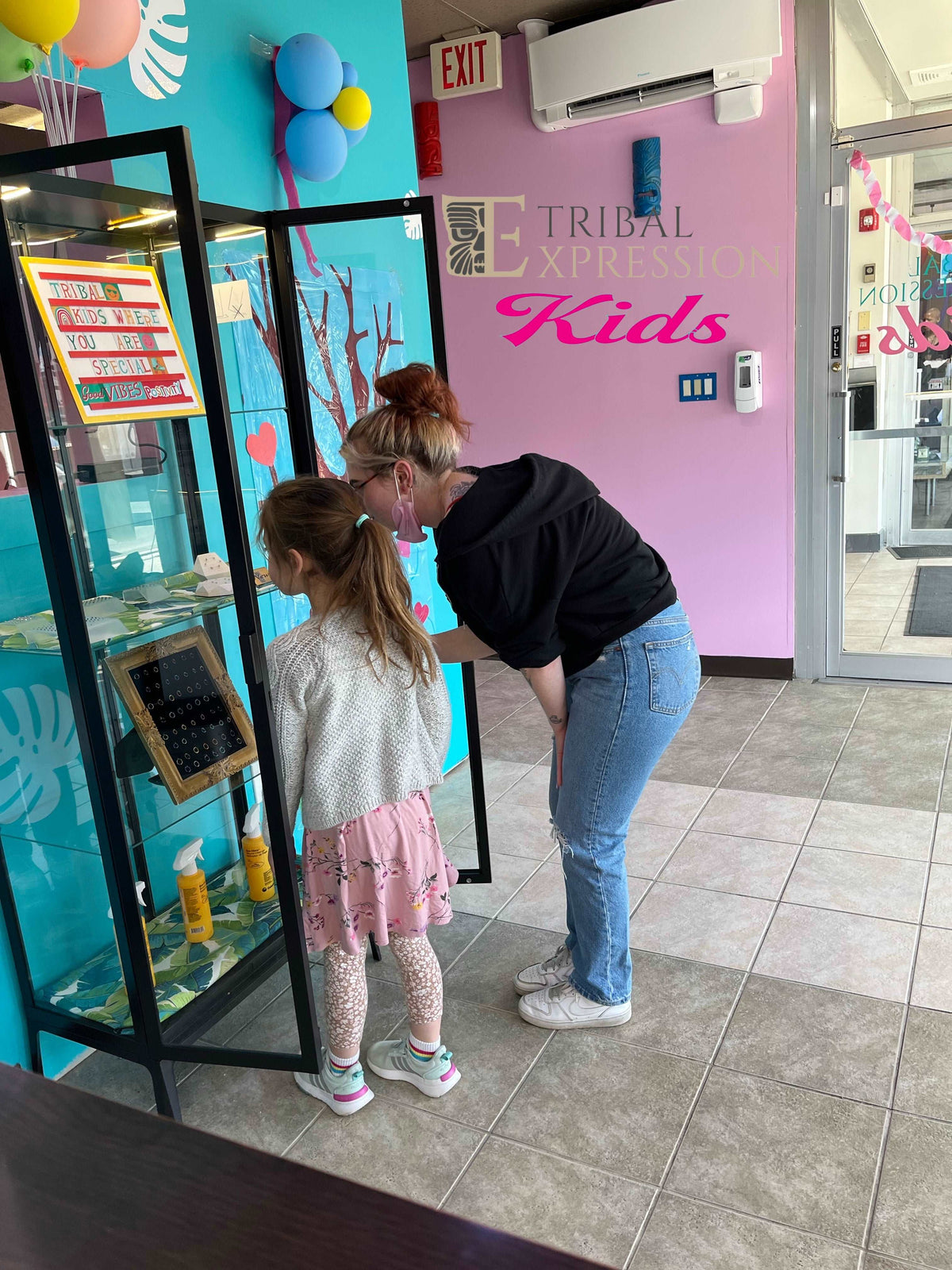 Piercer speaking with a child at the Tribal Expression Kids studio