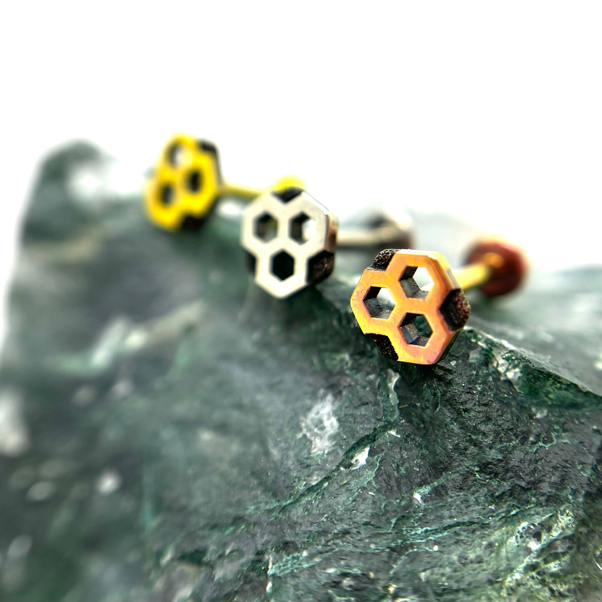 Honeycomb-shaped titanium ends in gold, polished and copper-toned finishes