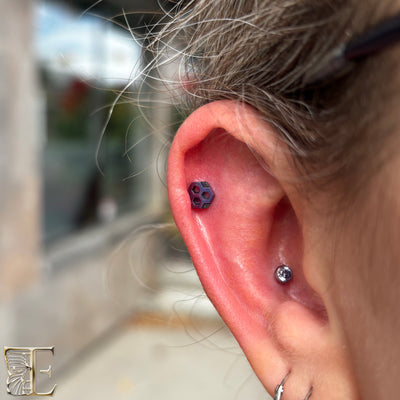 Purple gemstone jewelry in a cartilage piercing with smaller lobe studs