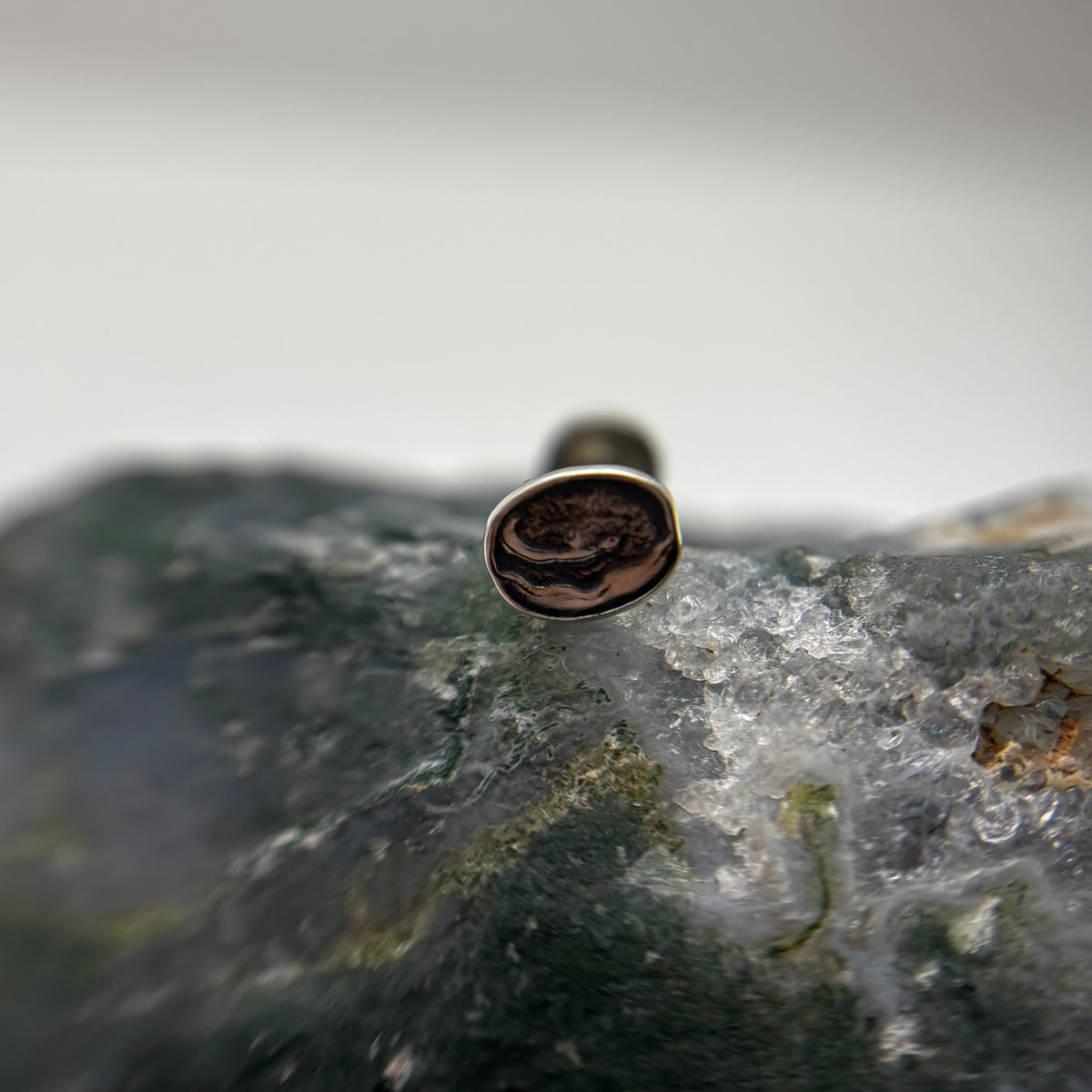 Silver filled doughnut-shaped jewelry end on a flat-back post