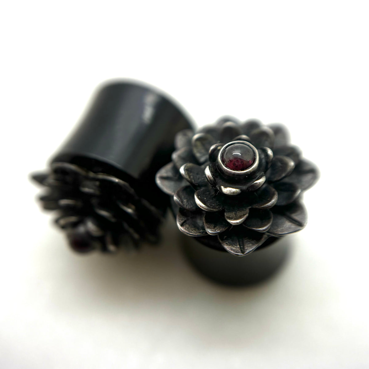 Dark wood double-flare plugs with layered flower-shaped fronts