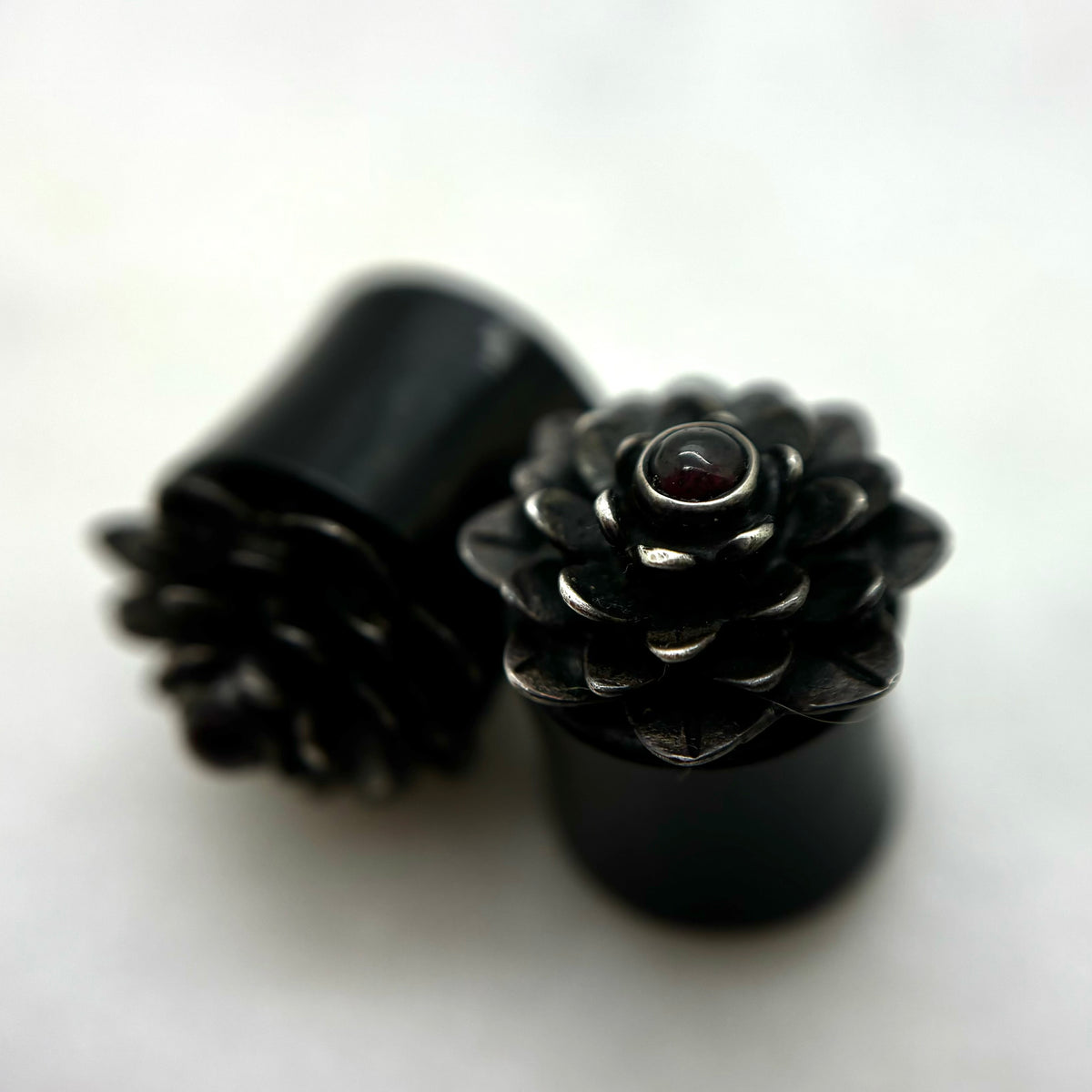 Dark wood double-flare plugs with layered flower-shaped fronts