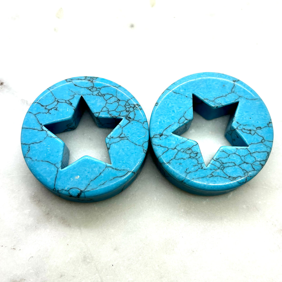 Pair of blue synthetic turquoise plugs with star-shaped cutouts